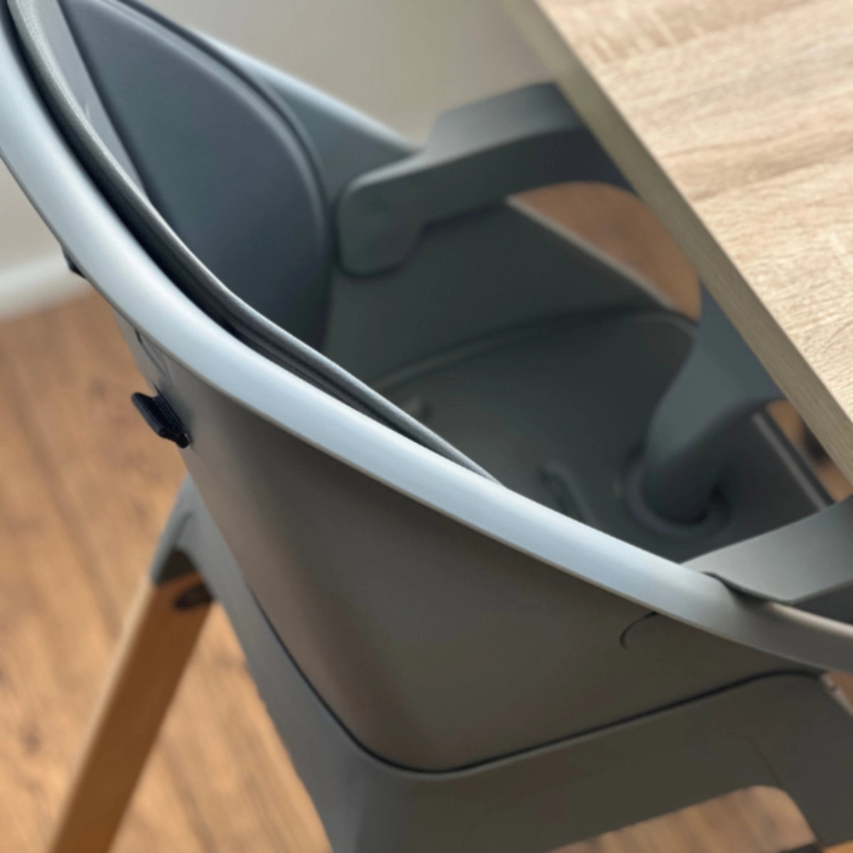 Close-up of the MOOSE Harper High Chair showing the charcoal grey seat and tray attachment.