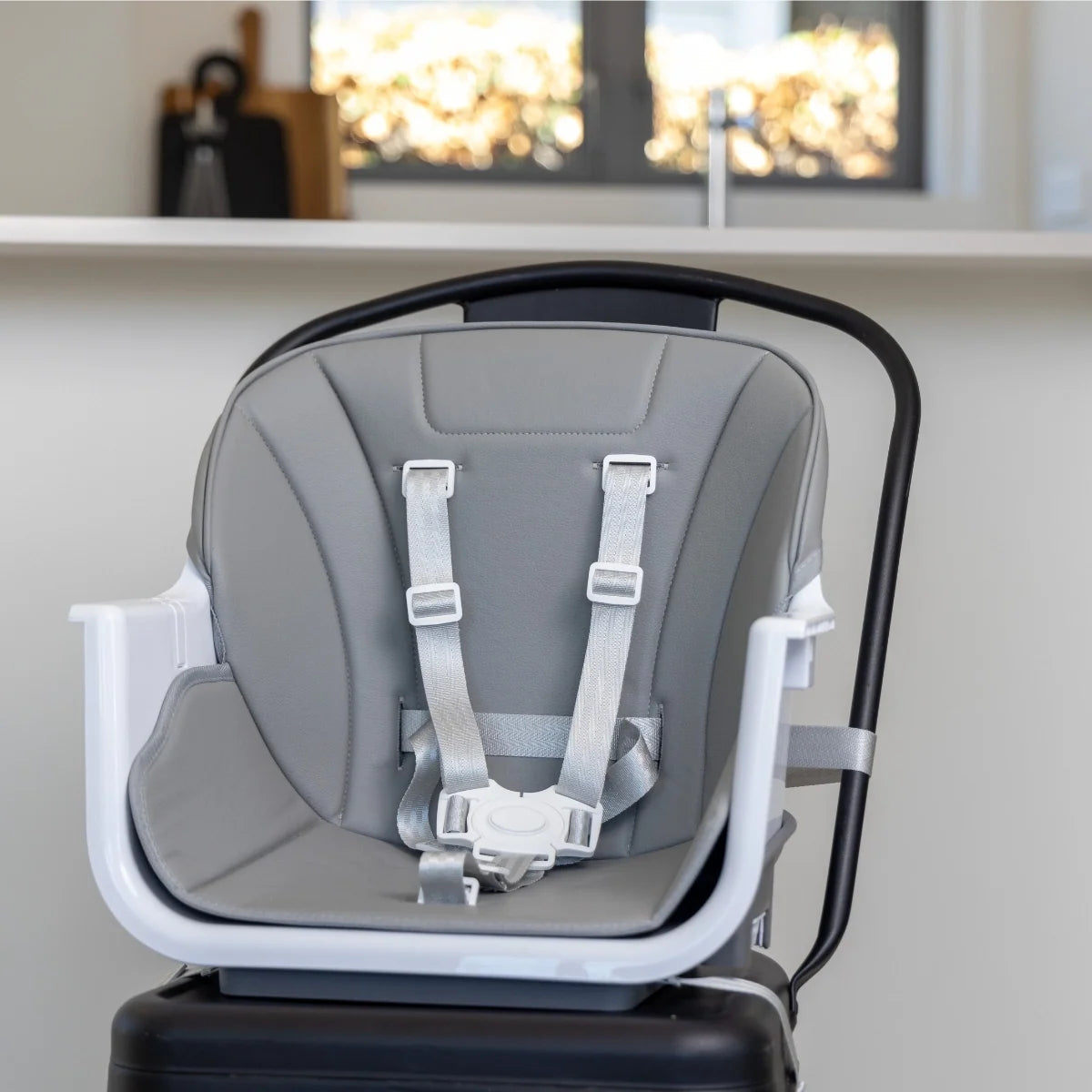 Close-up of the MOOSE Frankie high chair padded grey seat and five-point safety harness with the tray removed.