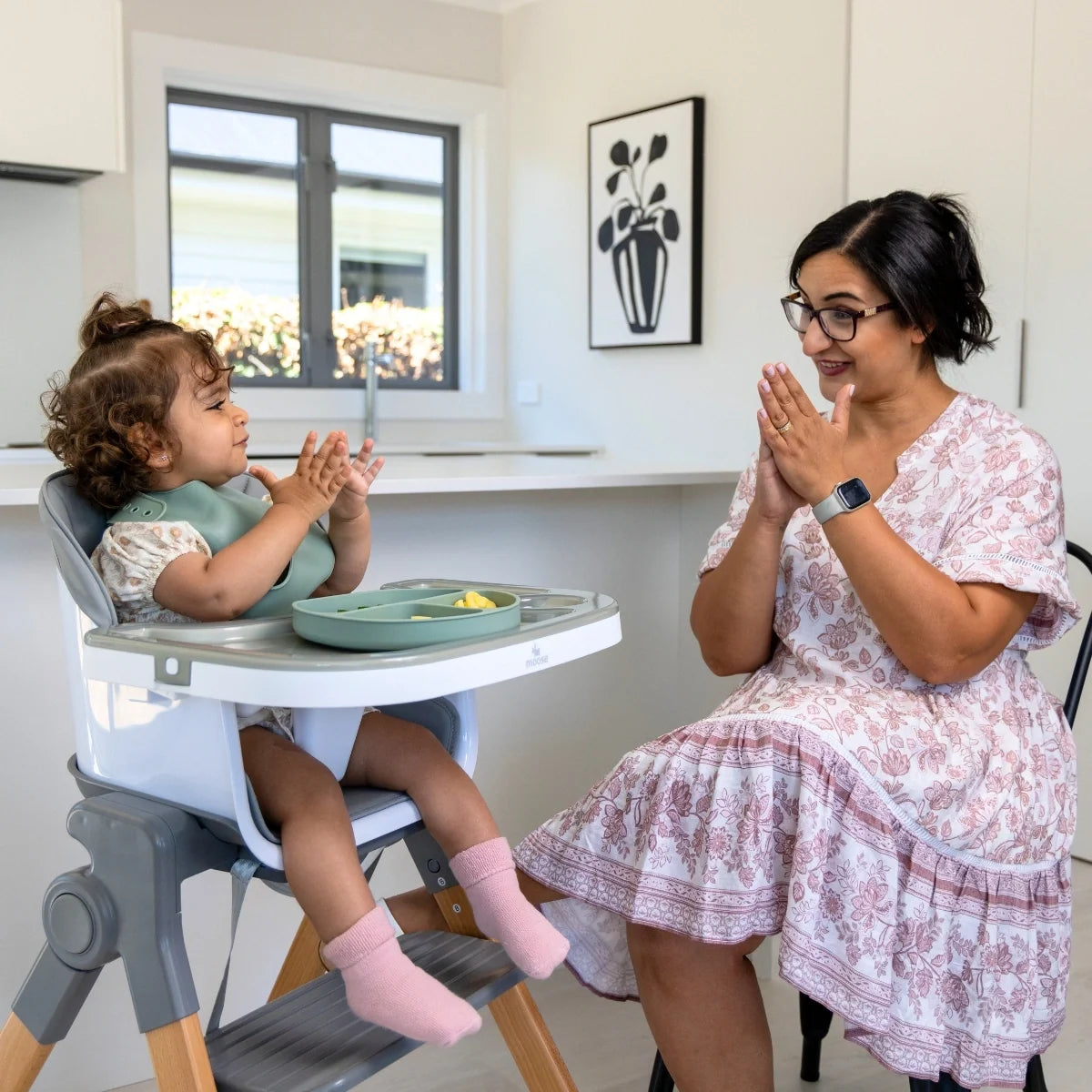 Parent and toddler sharing mealtime at a dining table with the MOOSE Frankie Foldable High Chair.
