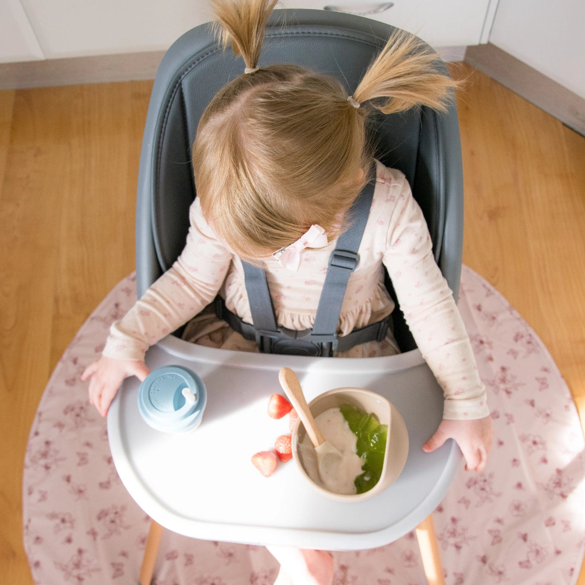 Overhead view of a baby eating in the MOOSE Harper High Chair with food on the tray.