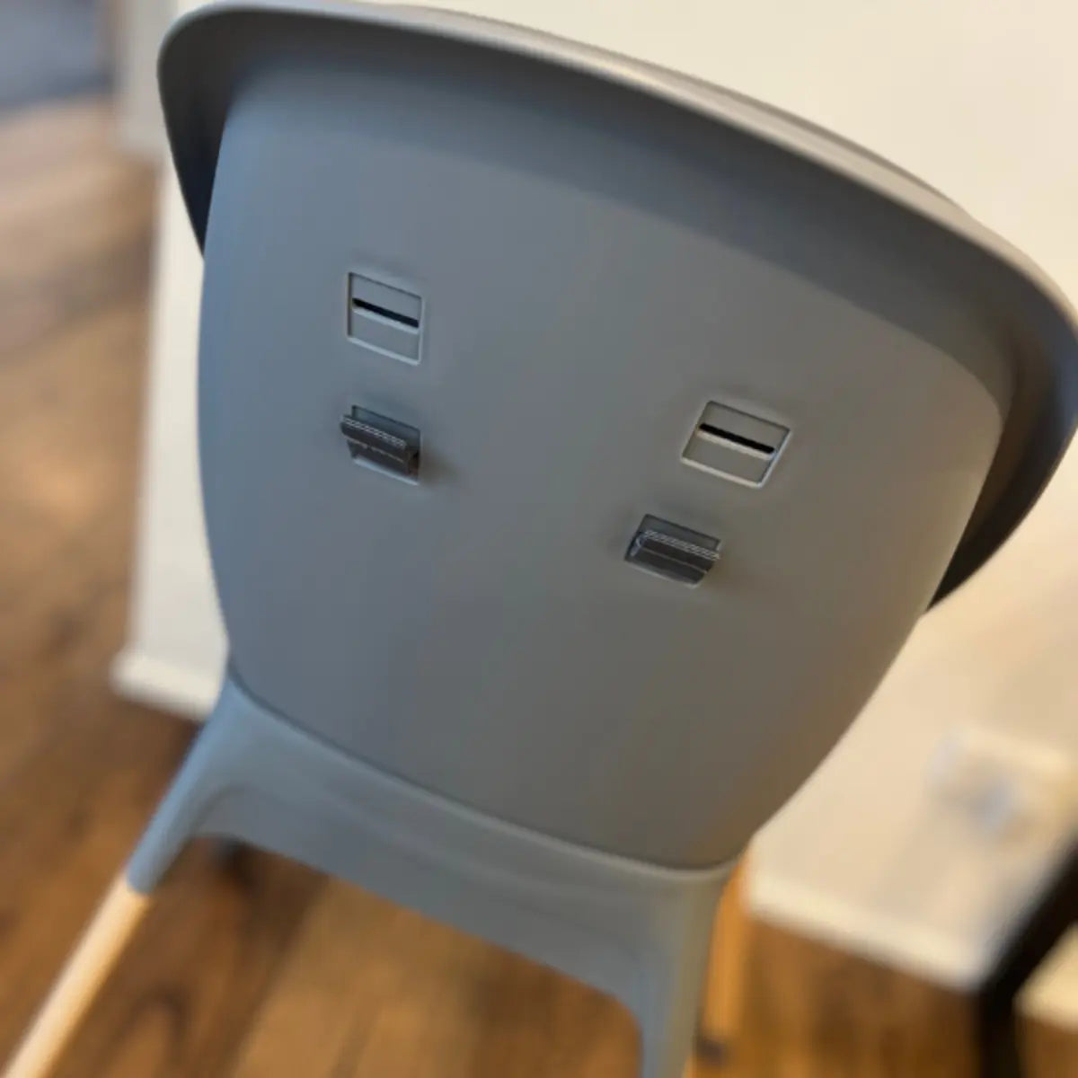 Rear view of the MOOSE Harper High Chair showing the charcoal grey backrest and wooden legs.