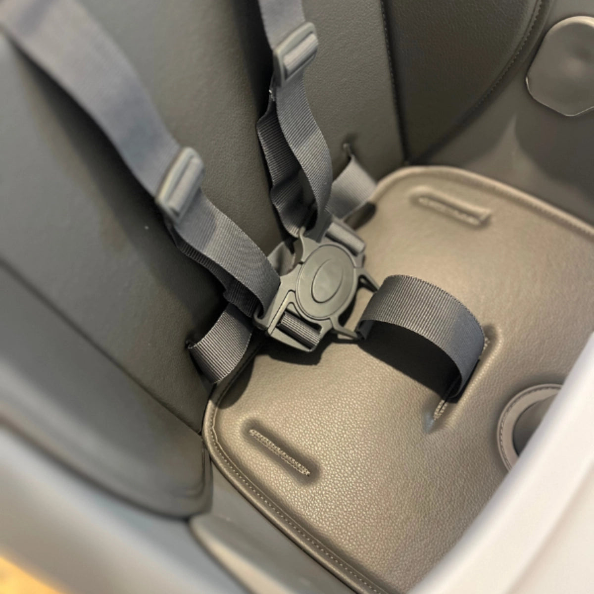 Close-up of the MOOSE Harper High Chair safety harness buckle and adjustable straps.